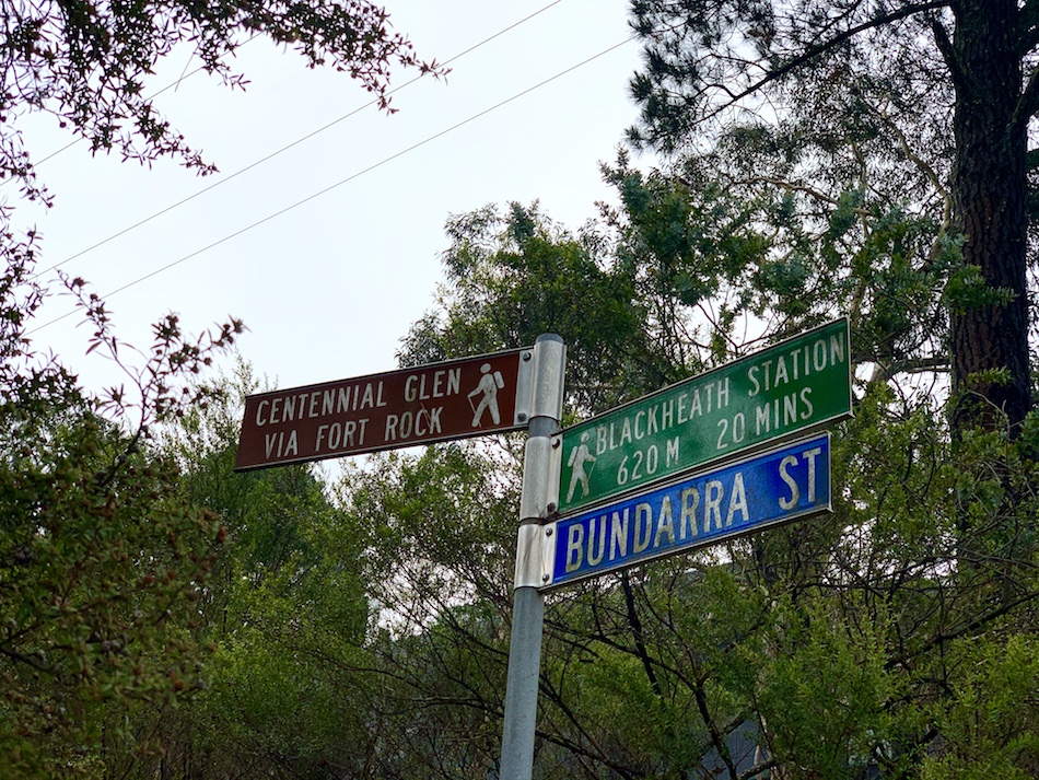 Street signs indicating which way to Centennial Glen Reserve.