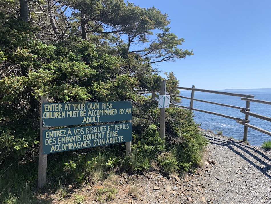 Entrance sign at the beginning of the trail that reads "Enter at your own risk. Children must be accompanied by an adult.: