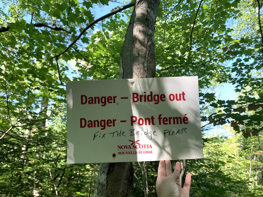 Danger sign on the North River Falls trail letting hikers know that the bridge is out.