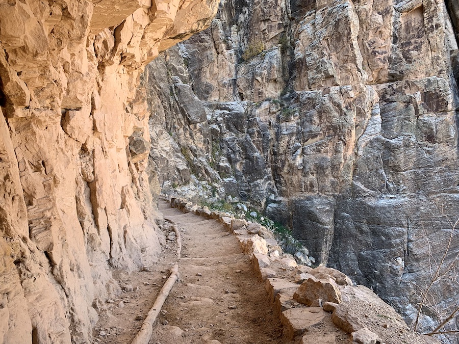 Carved trail along the Bright Angel Trail surrounded by rock walls. 