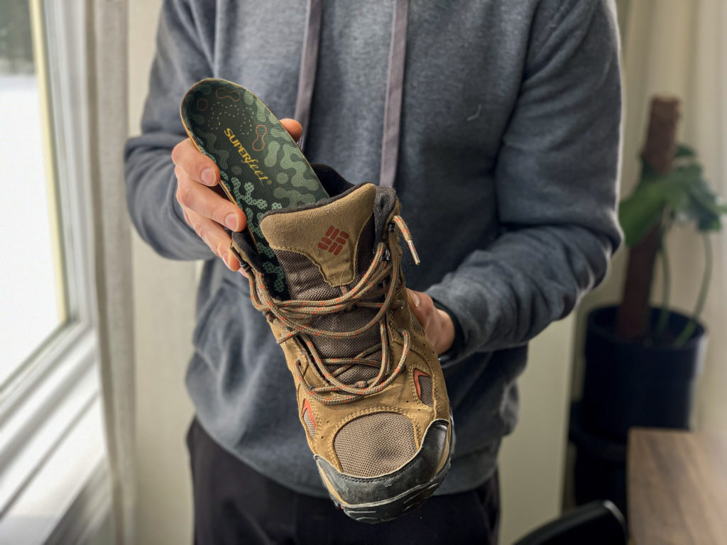 Arthur putting Superfeet Adapt Hike Max Insole inside of his hiking boots. 