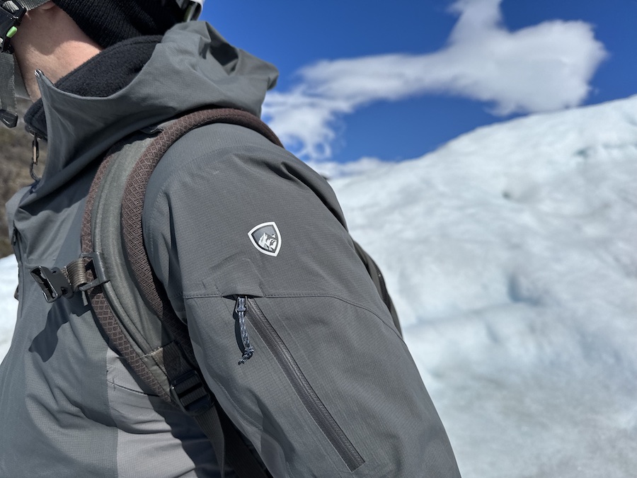 Close up of the logo on the KÜHL One Shell with glacier in the background.