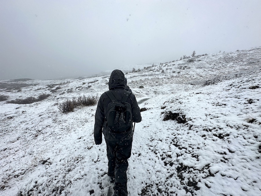 Arthur hiking through a snowed cover terrain in Patagonia while winter hiking. 