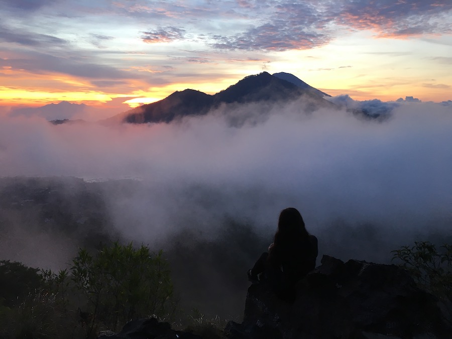 Julia on top of Mount Batur In Bali with a sunset